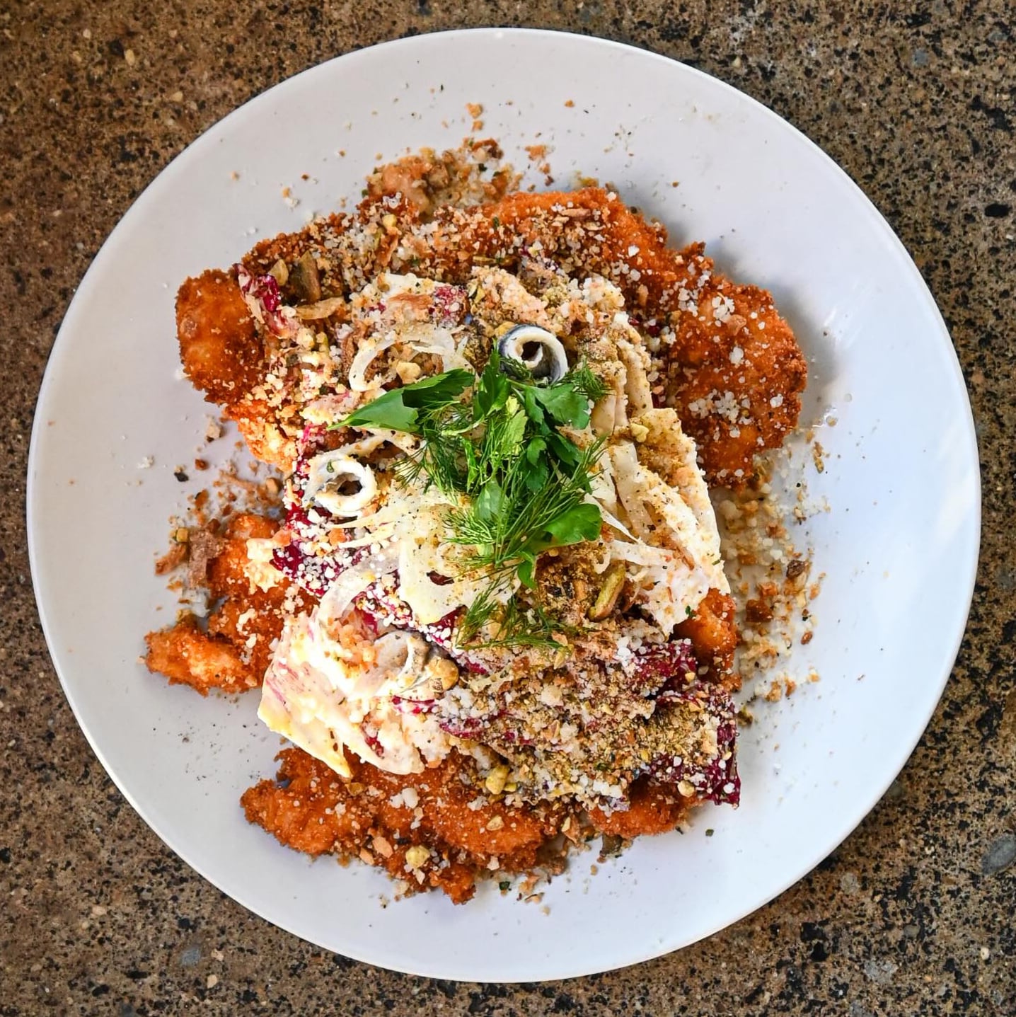 Artfully plated vegetable dish with crispy elements and fresh herbs