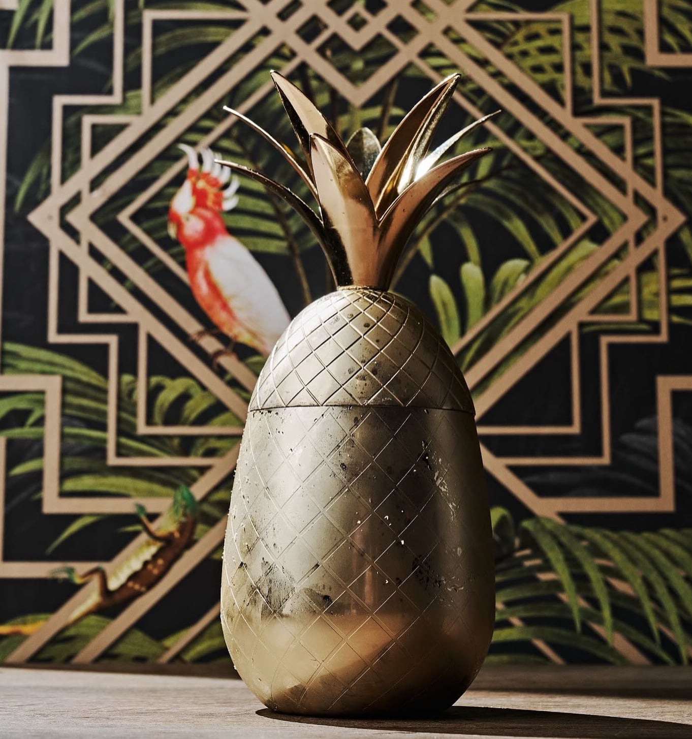 Golden pineapple centerpiece with geometric wallpaper backdrop