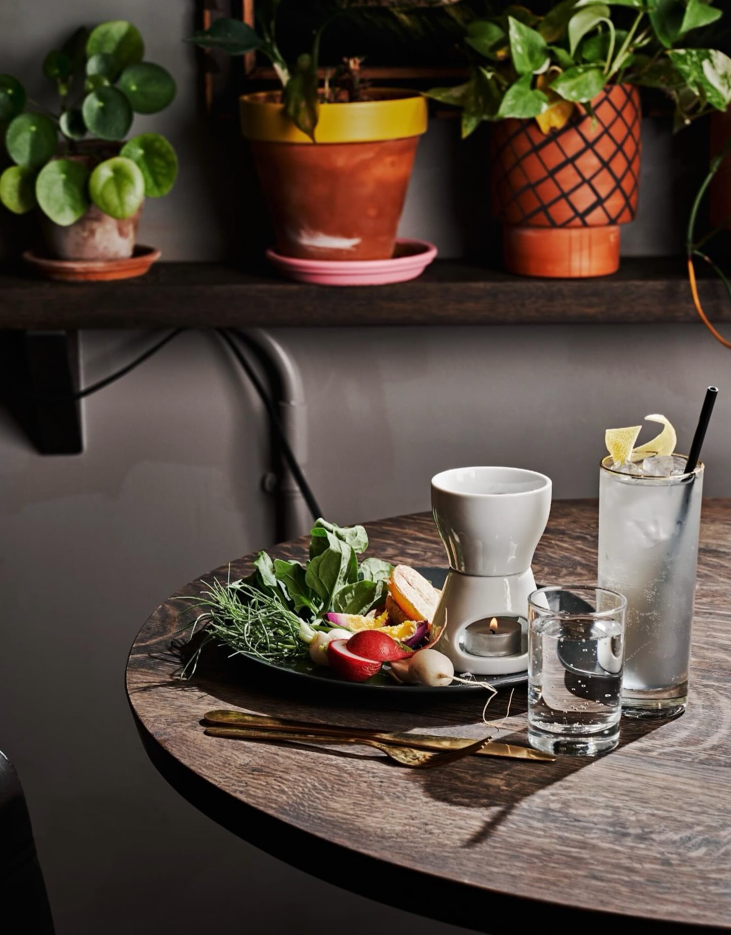 Dining table with house cocktail and locally-sourced vegetable plate