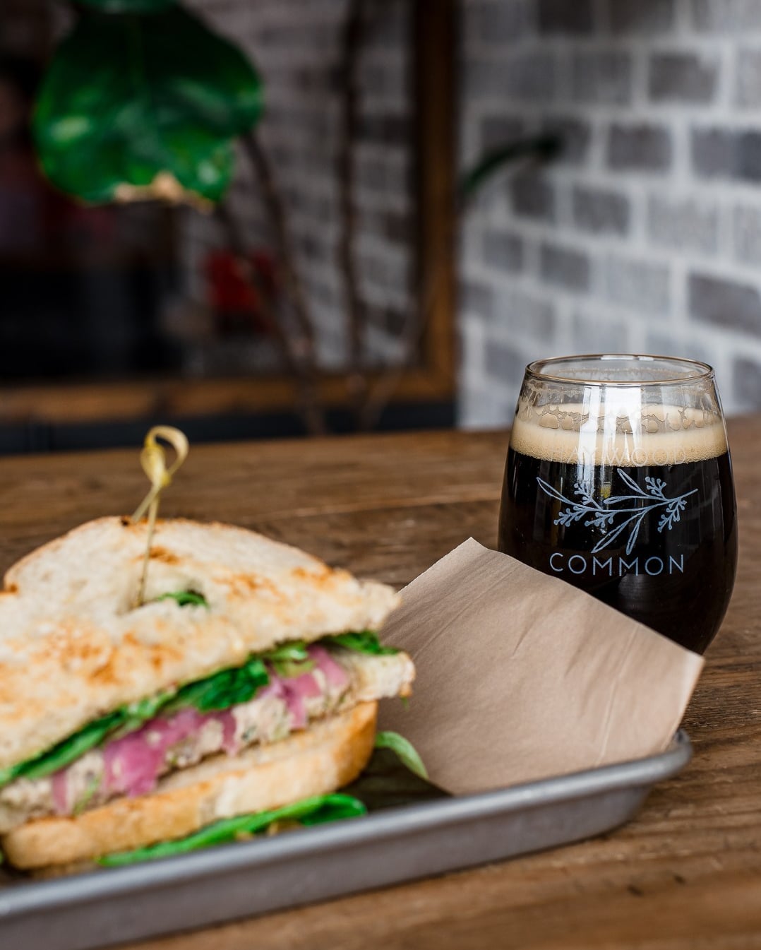 Panini sandwich and draft beer with branding detail at Common.