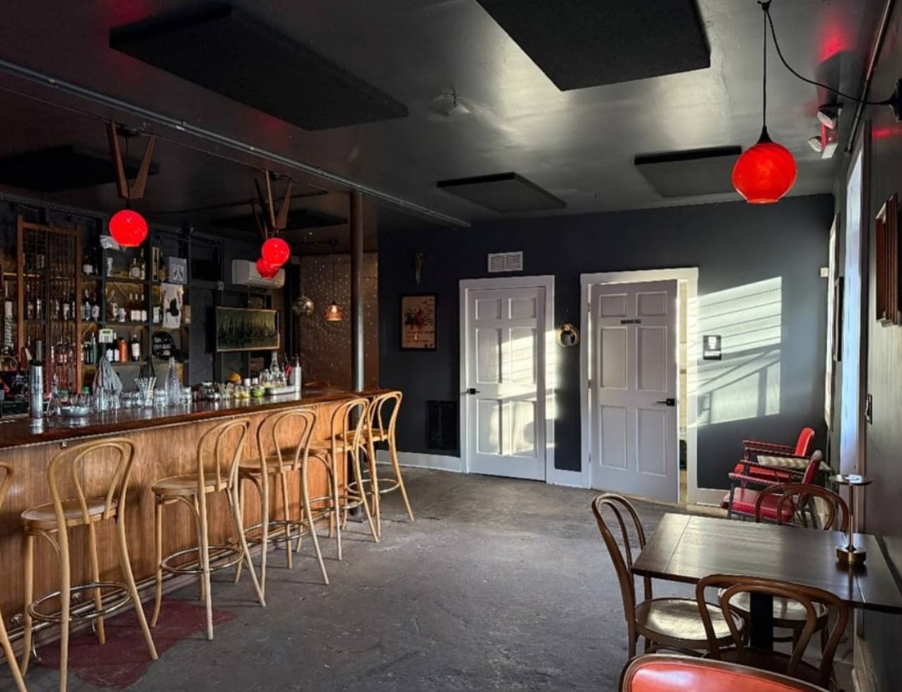 Daylit interior with wooden bar and red globe lights