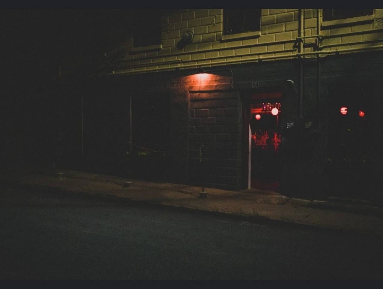 Brick entrance at night with red light inside