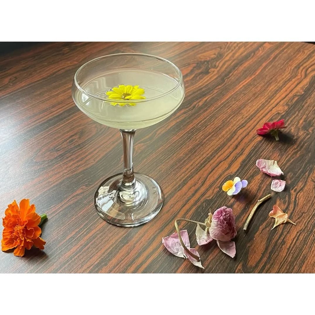 Signature cocktail garnished with fresh edible flowers