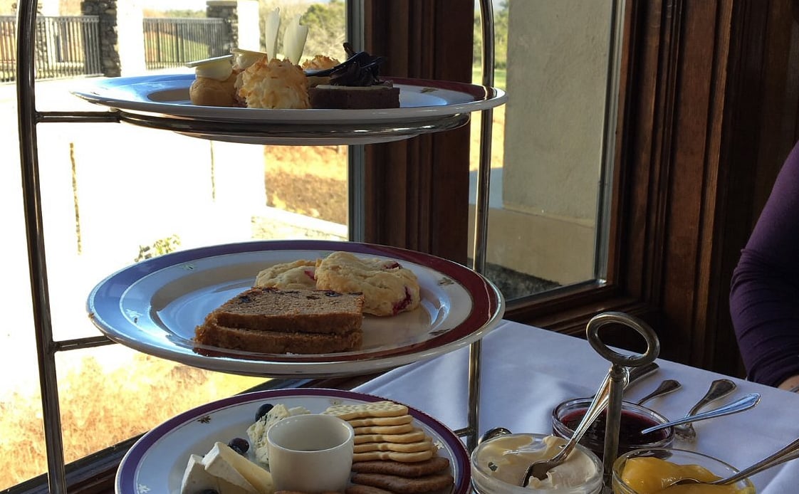 Tiered afternoon tea service with pastries, scones, and artisanal bites