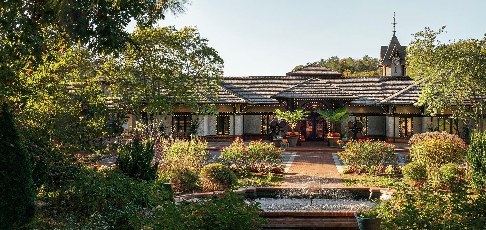 Inn on Biltmore Estate exterior with lush gardens and porch — entrance to the Library Lounge
