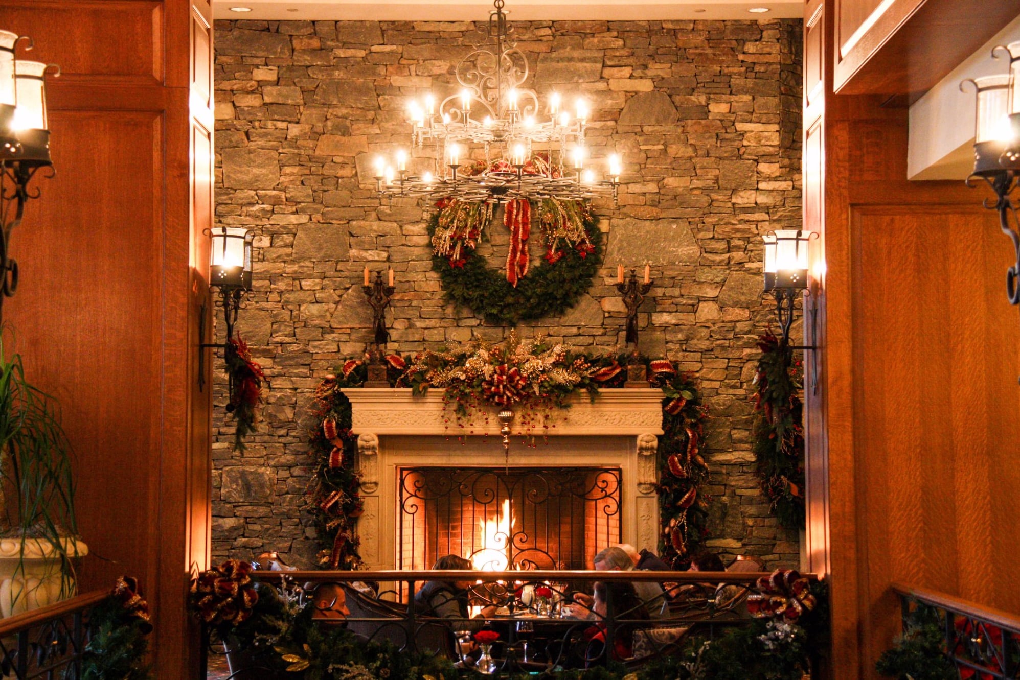 Stone fireplace with warm chandelier lighting at the Library Lounge