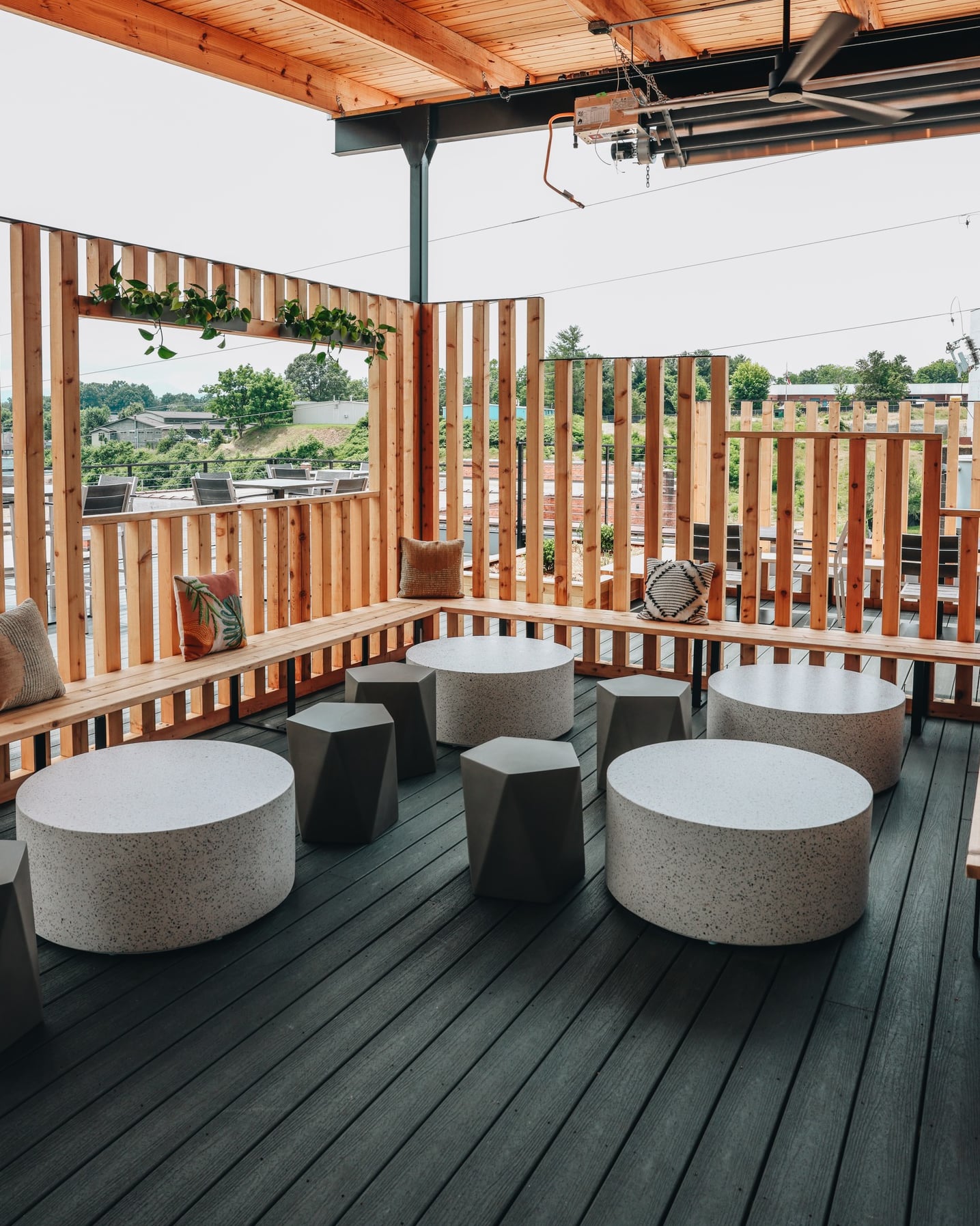 Contemporary rooftop lounge featuring custom wood slat privacy screens and terrazzo tables.