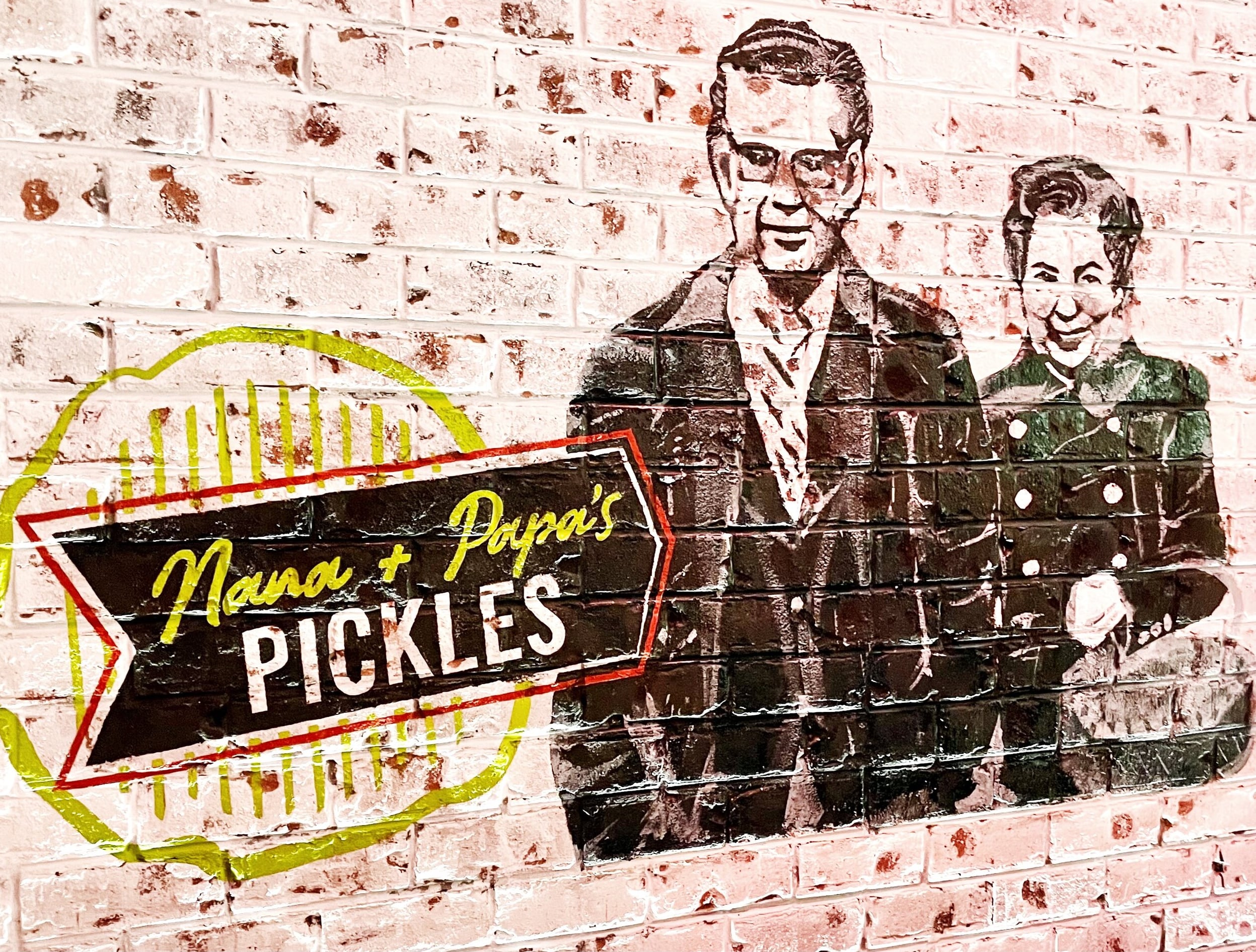 Whimsical brick wall mural featuring the venue's Nana and Poppy figures.