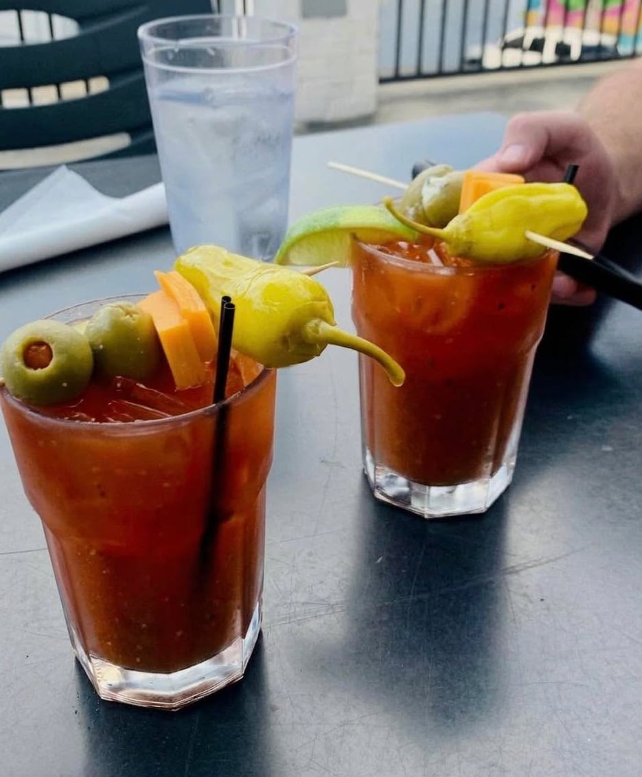 Classic Bloody Mary drinks served with pickled peppers and cheese skewers.