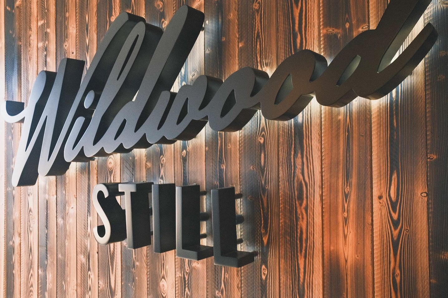 Wooden interior signage displaying the Wildwood Still logo.