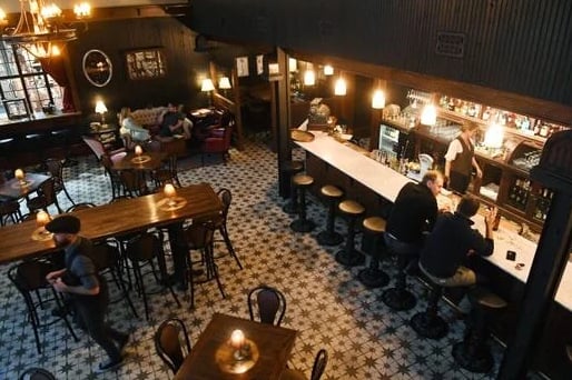 Overhead view of the bar counter with bartender at work and full backbar at Antidote