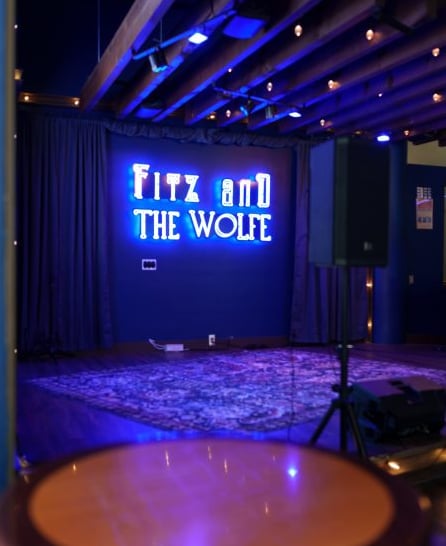 Main stage venue interior with 'Fitz and The Wolfe' neon signage.