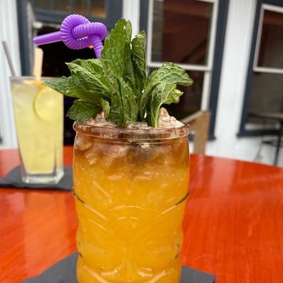 Tiki-style orange cocktail with fresh mint on the rooftop patio