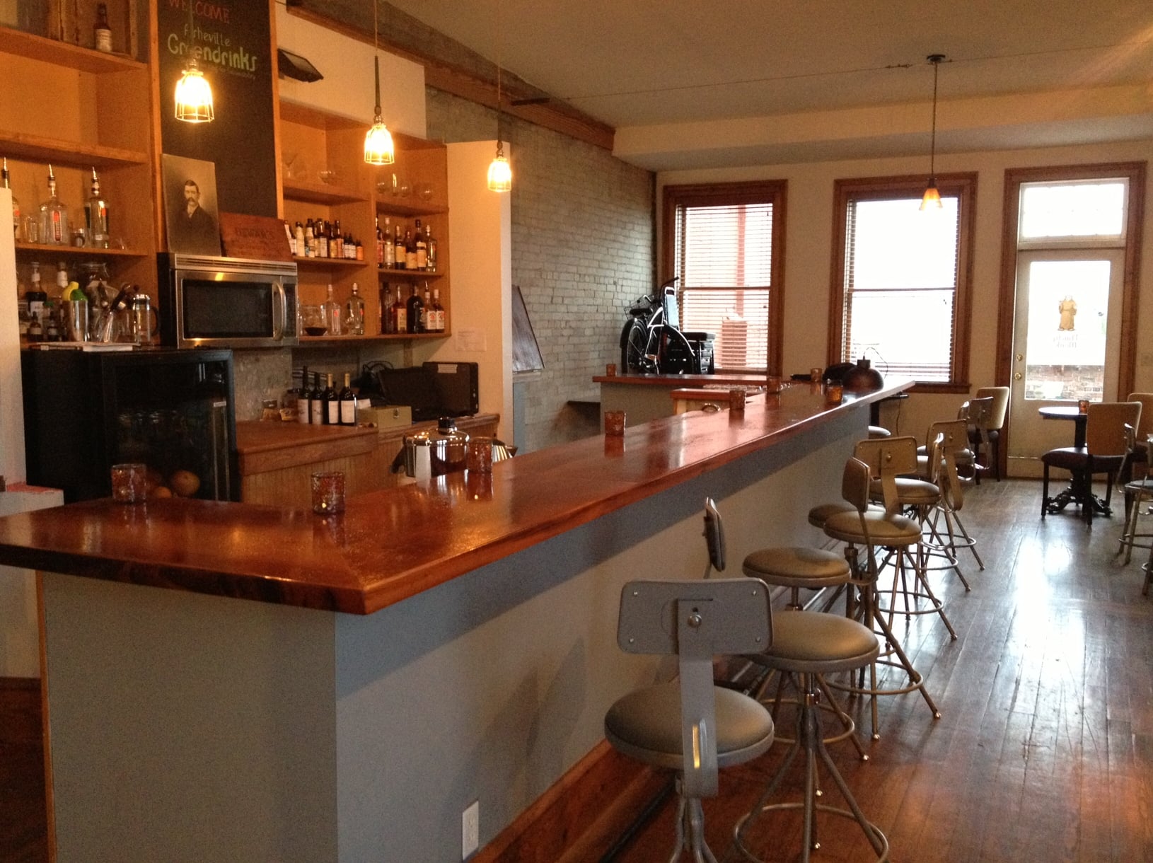Classic copper-topped bar counter with backbar bottles and bar stools