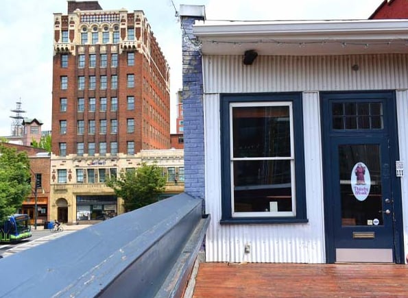 Rooftop-level entry with Thirsty Monk signage and downtown Asheville skyline