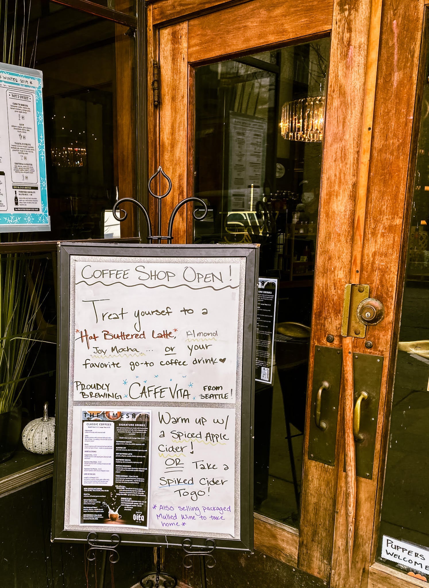 Charming storefront entrance with craft coffee and cocktails signage