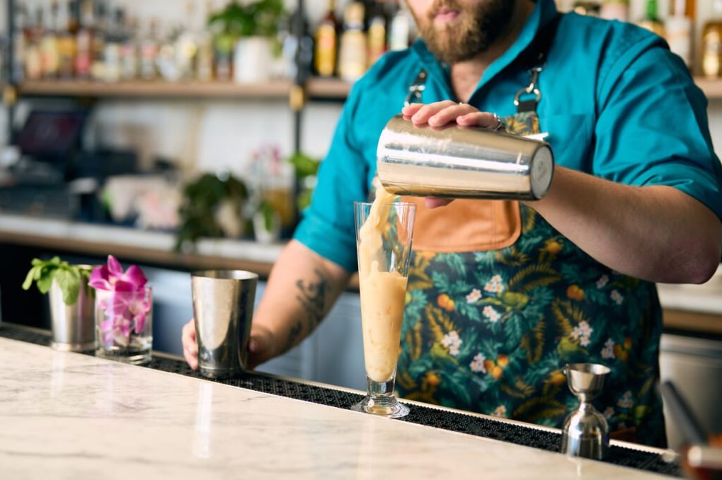 Craft cocktail being poured at the sleek marble bar.