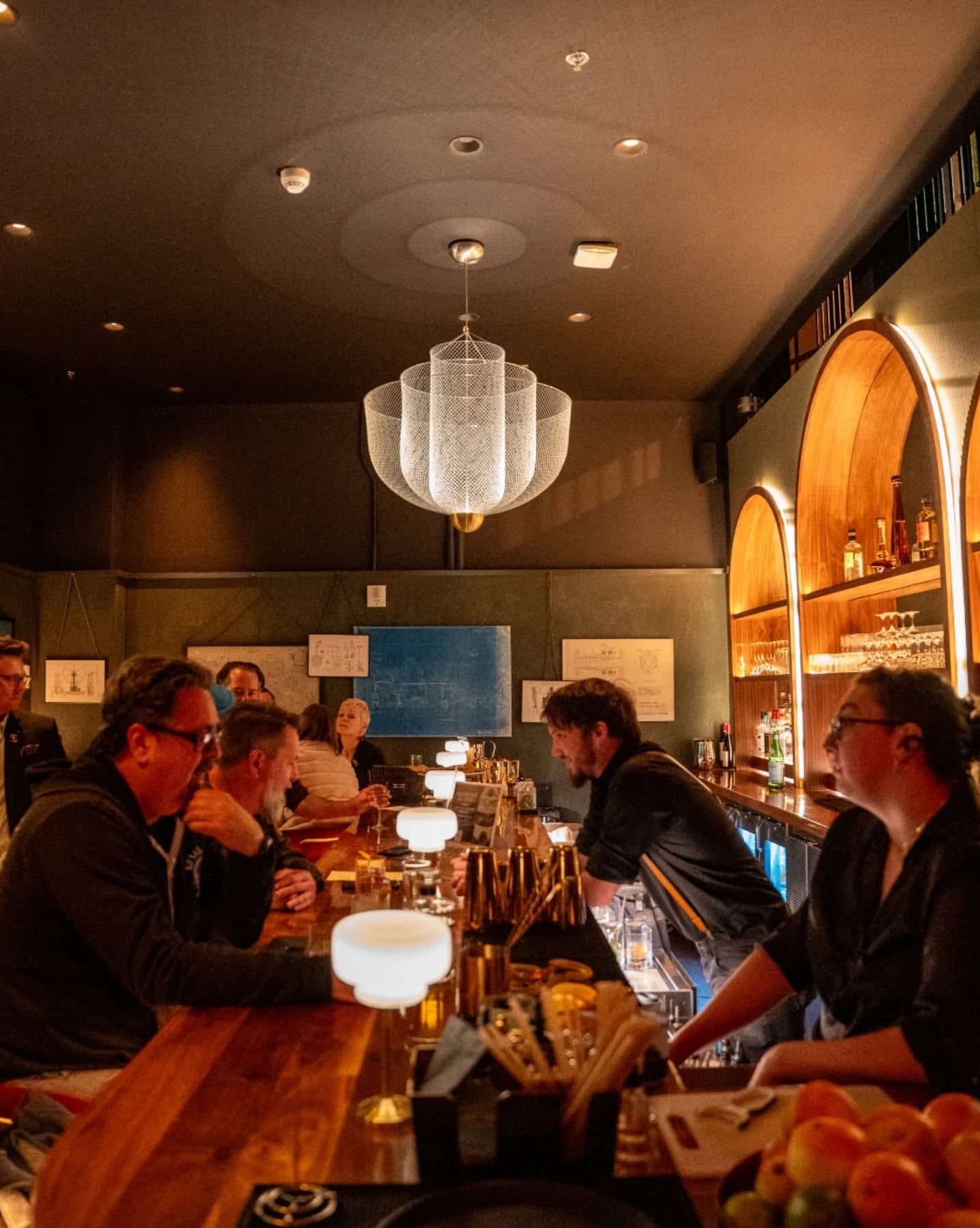 Vibrant bar interior with warm lighting and custom arched shelving