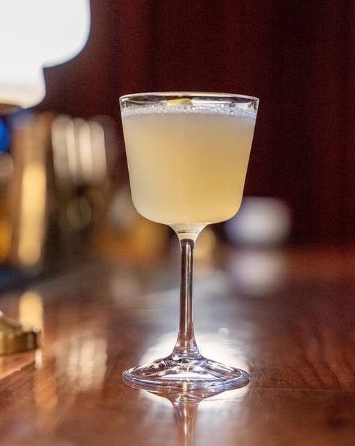 Delicate pale cocktail in elegant coupe glass