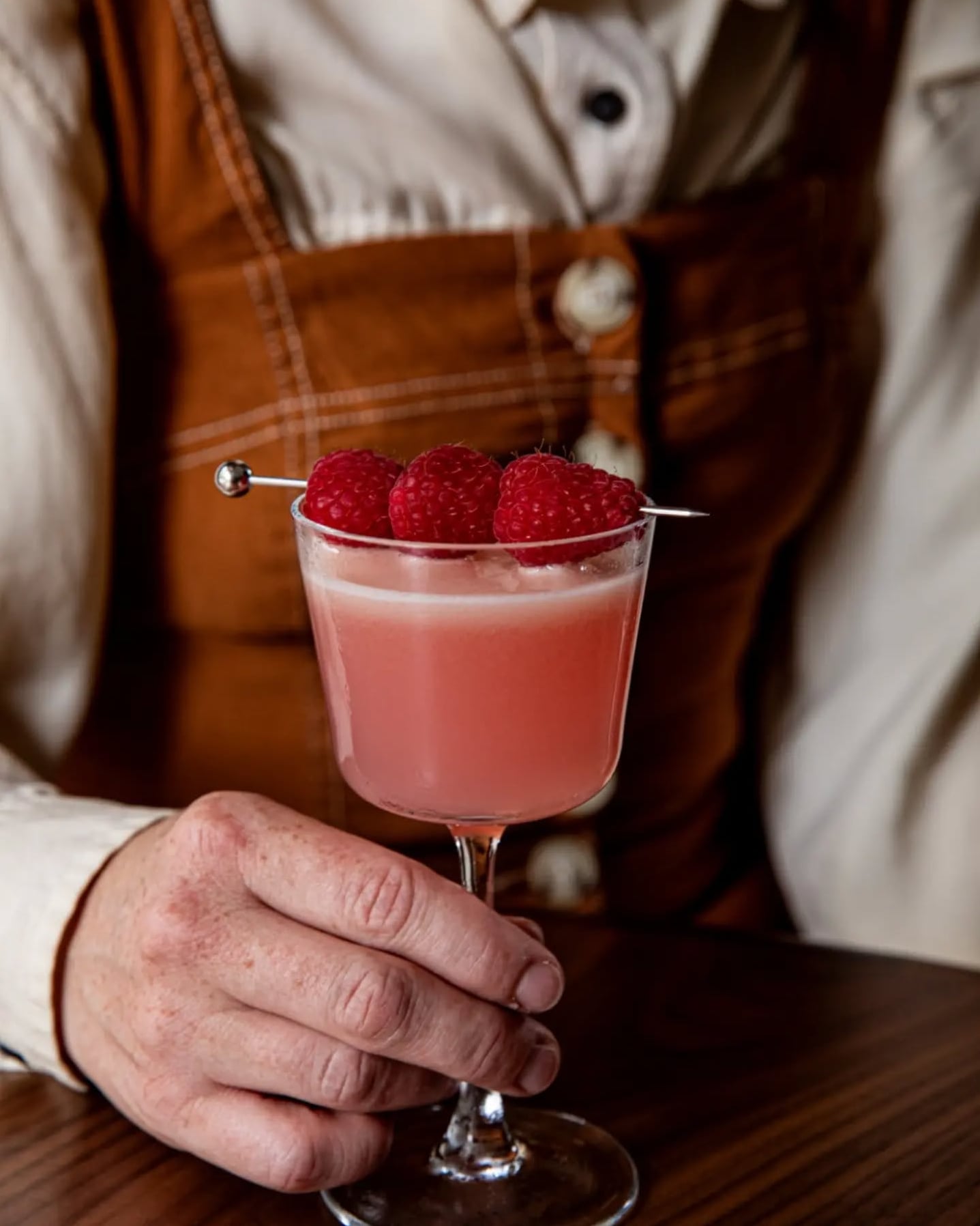 Handcrafted raspberry cocktail served in coupe glass