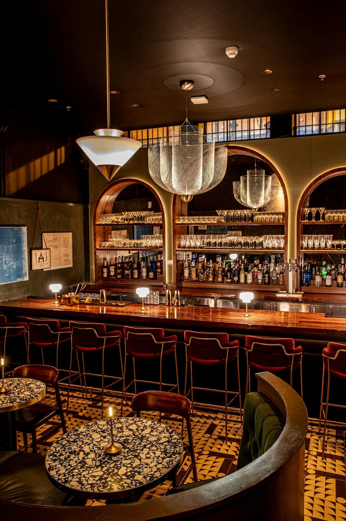 The main bar featuring exposed brick arches and vintage-style chandeliers.