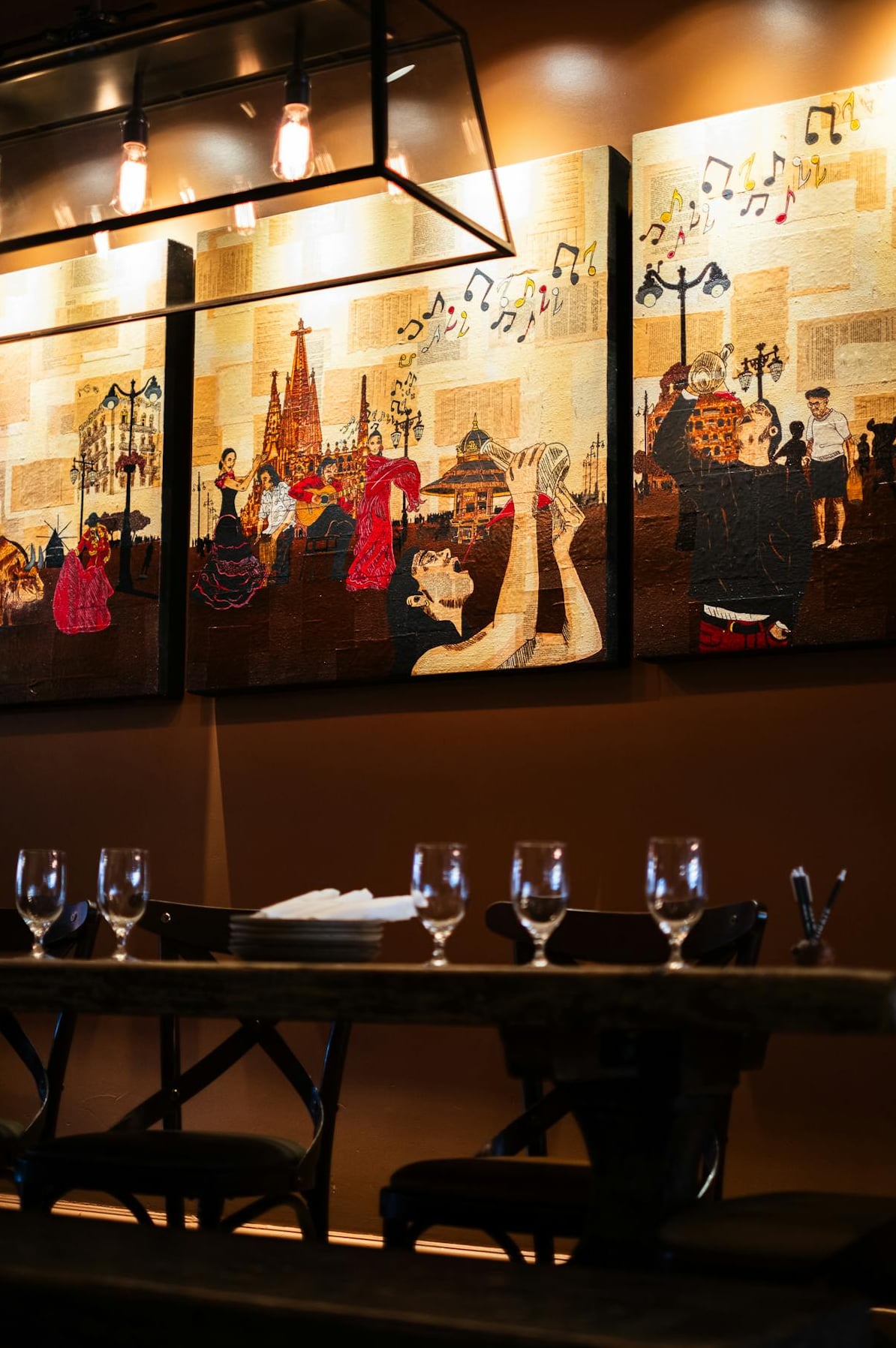 Distinctive Spanish-themed mural above dining tables, warm ambient lighting