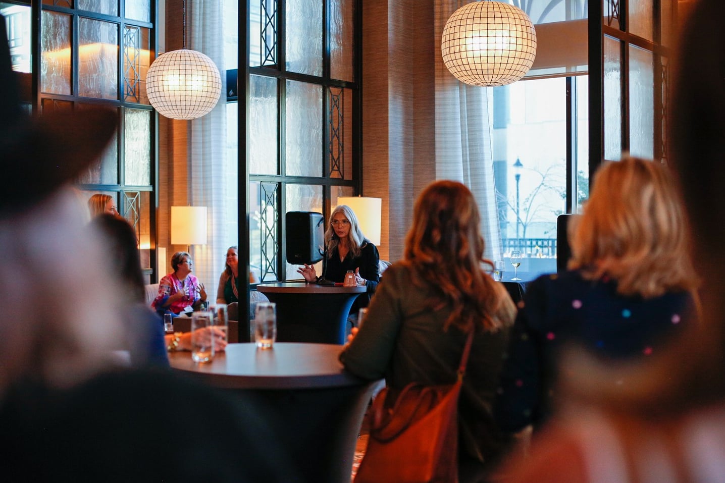 Modern interior hosting a speaker event with globe fixtures.