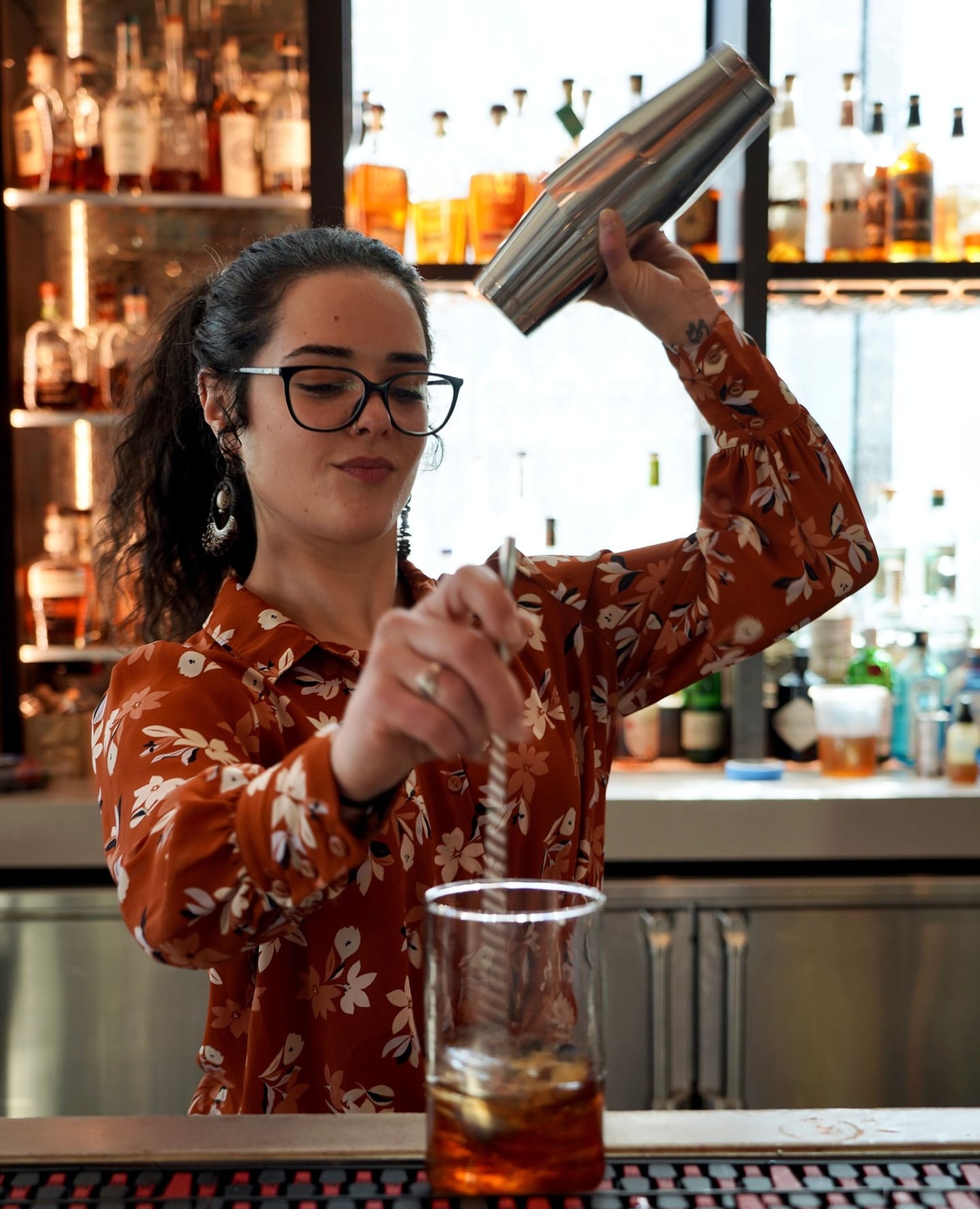 Bartender mixing cocktails with professional flair.