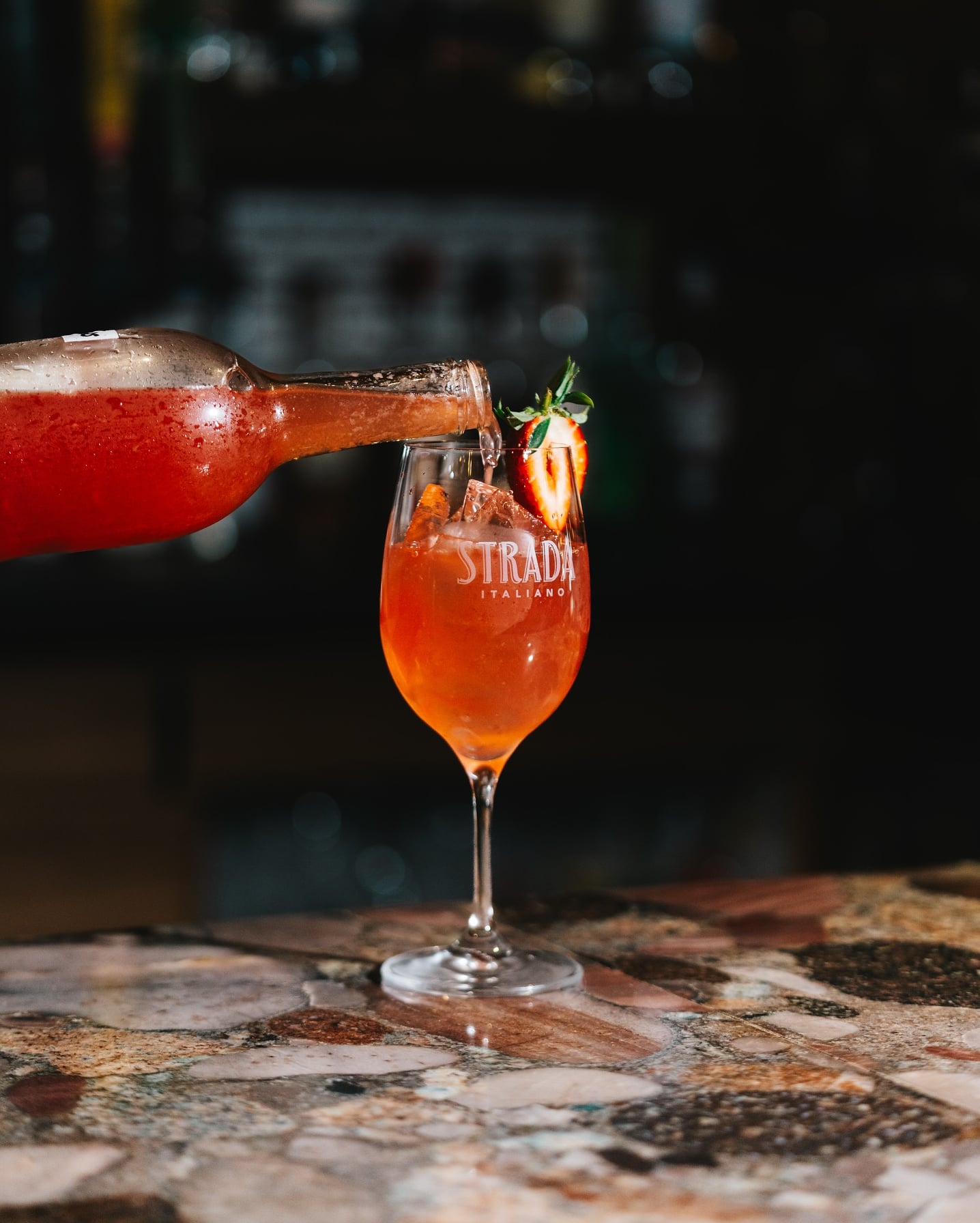 Signature red cocktail being poured on the rooftop.
