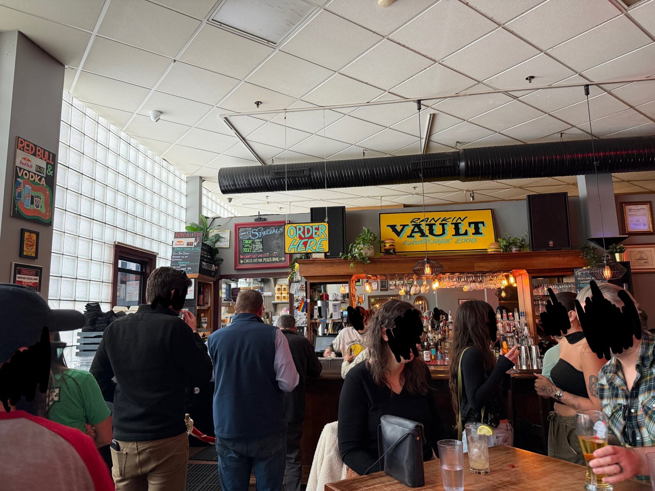 Bustling bar counter beneath the iconic Rankin Vault sign
