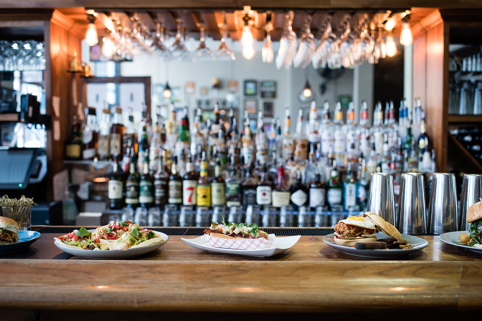 Plated entrees served at the bar overlooking a extensive liquor selection.