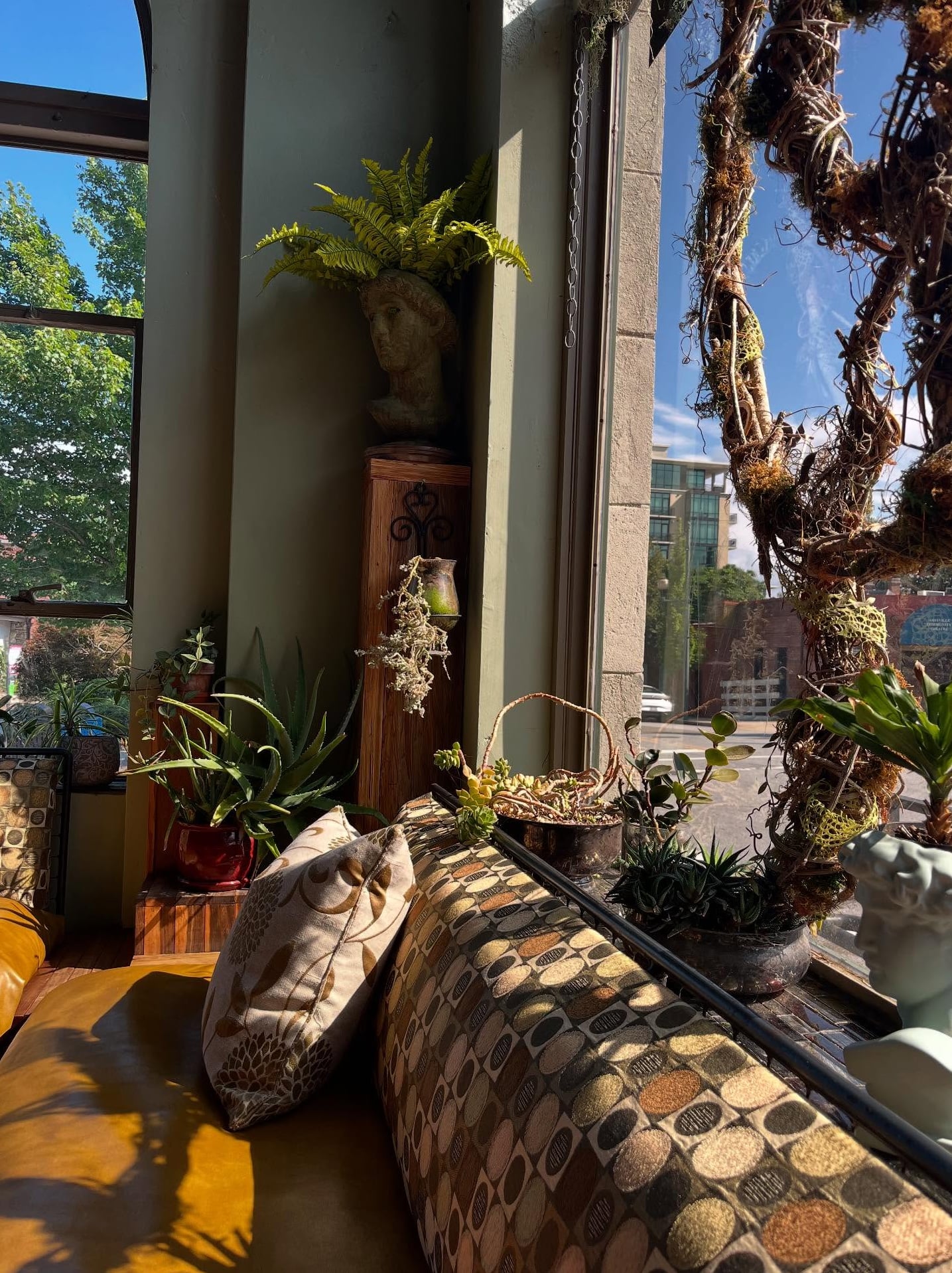 Eclectic interior seating nook adorned with lush greenery and artistic installations.