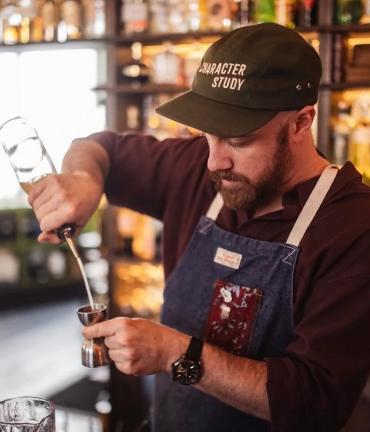 Bartender preparing drink with precision at the bar.