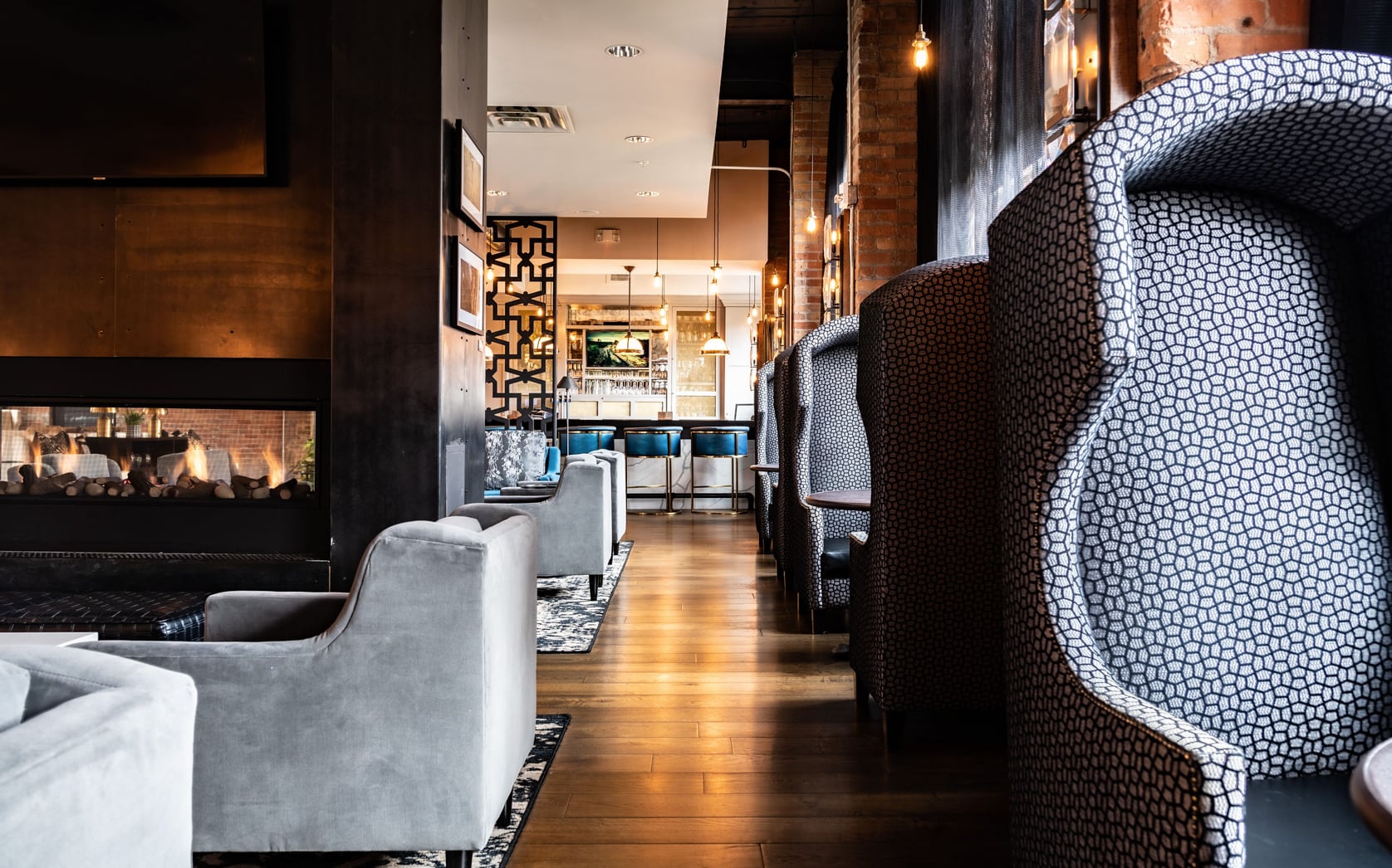 Modern interior lounge featuring high-backed patterned seating and ambient lighting.