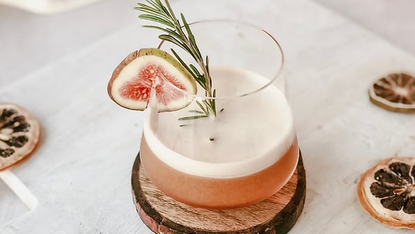 Signature cocktail with fresh fig and rosemary garnish