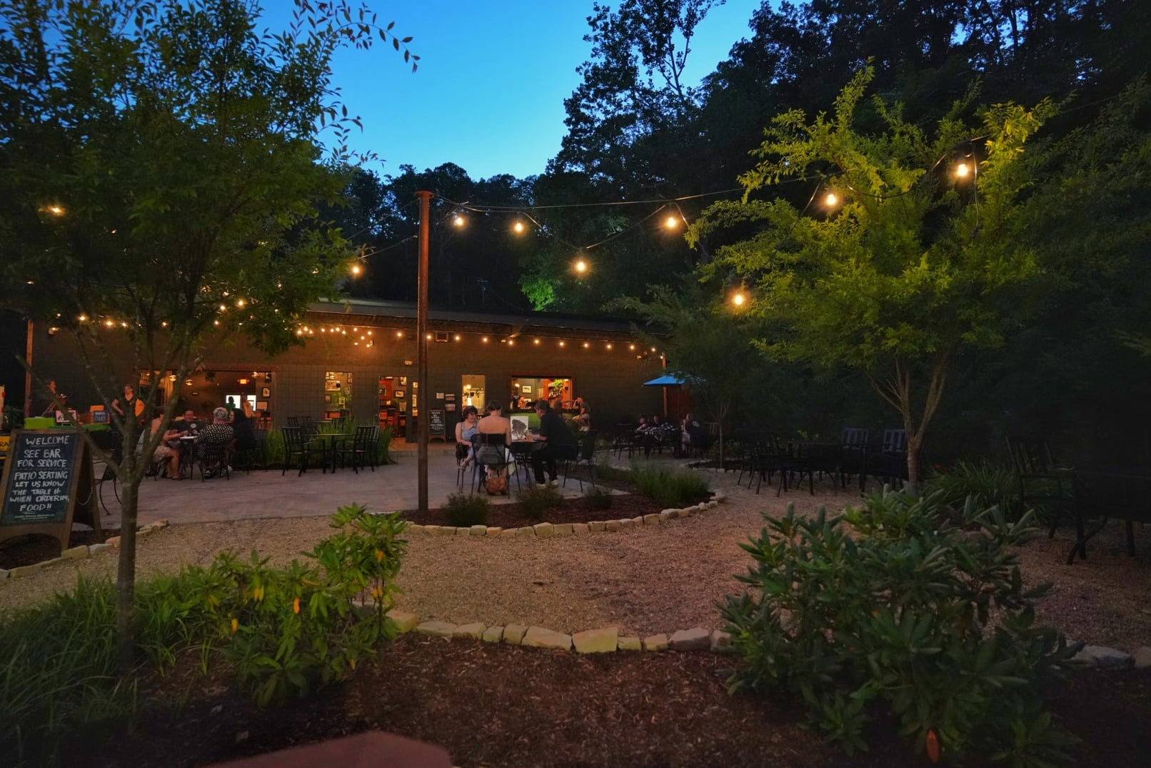 Charming evening exterior with string lights inviting guests to the patio.