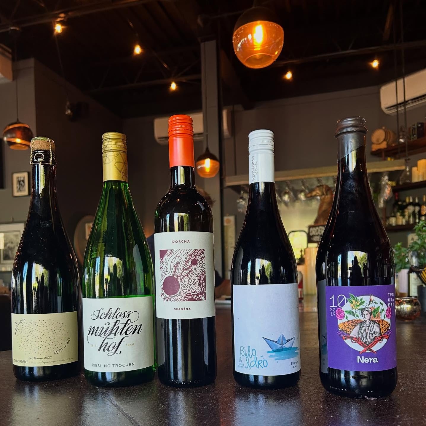 Selection of natural wines on display at the bar with warm amber lighting.