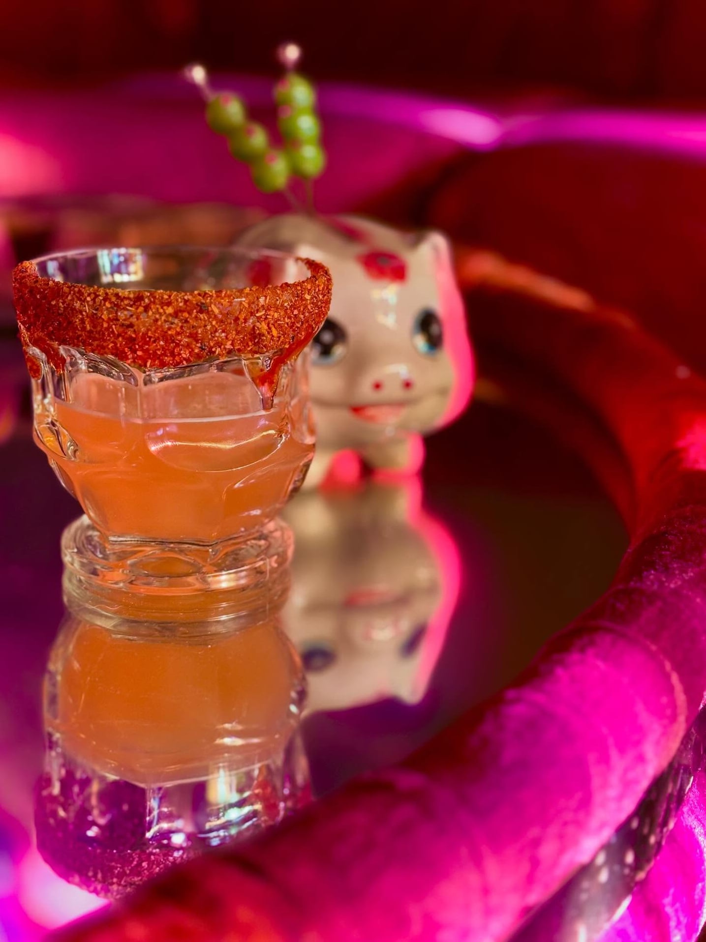 Signature amber cocktail with sugar rim and olive skewer