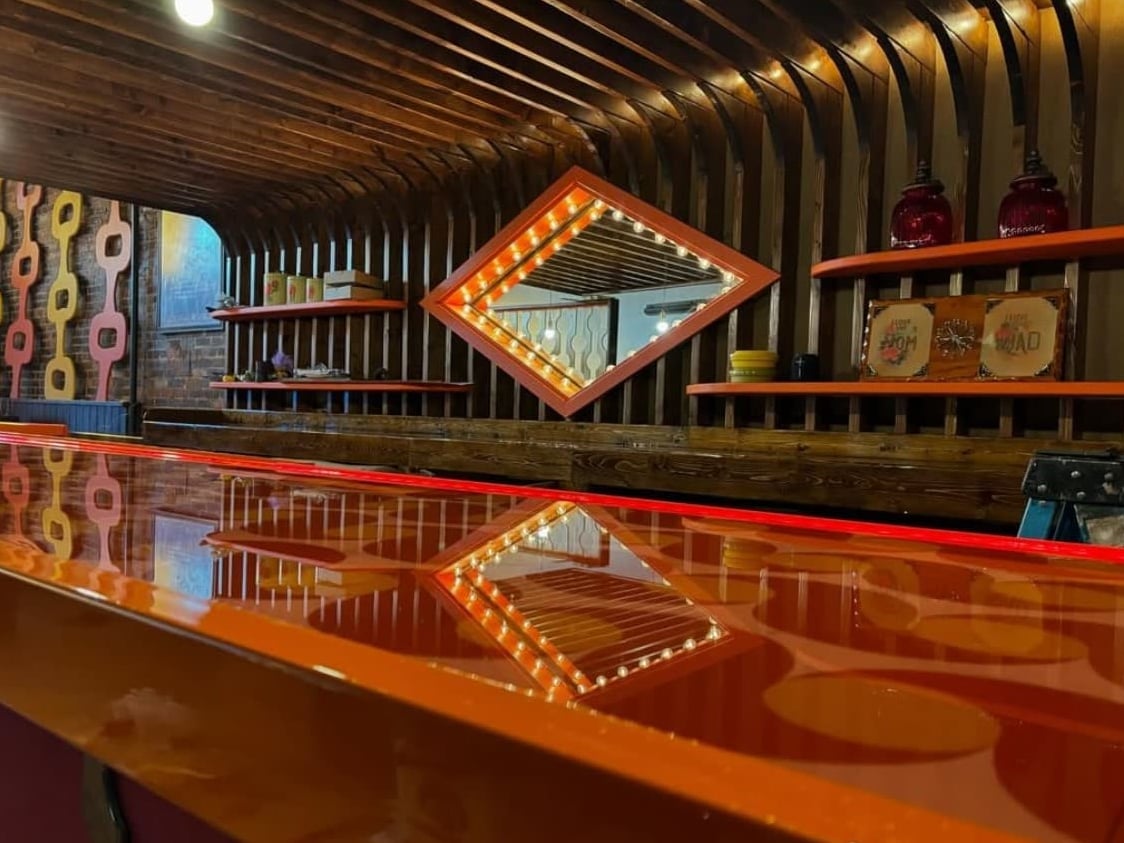 The retro bar counter with diamond mirror and neon lighting at DayTrip.