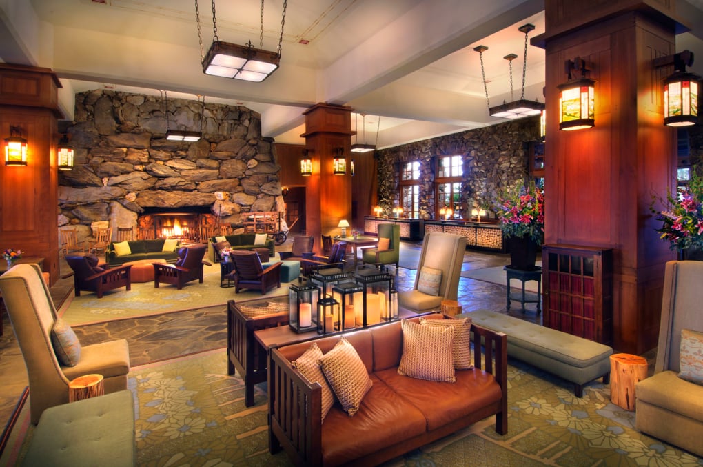 Grand Great Hall lobby with its iconic stone fireplace, mission-style seating, and warm pendant lanterns