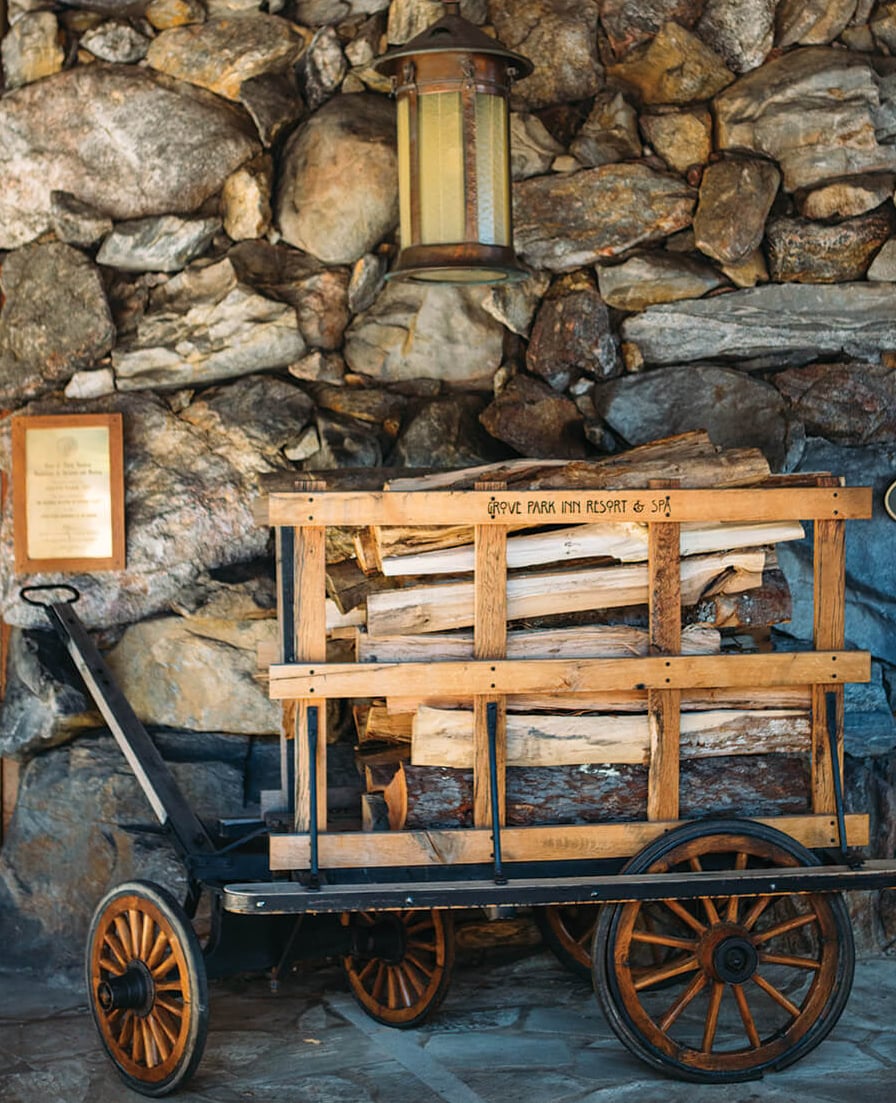 Historic firewood cart beside the Great Hall's stone walls — part of the inn's storied fireplace tradition