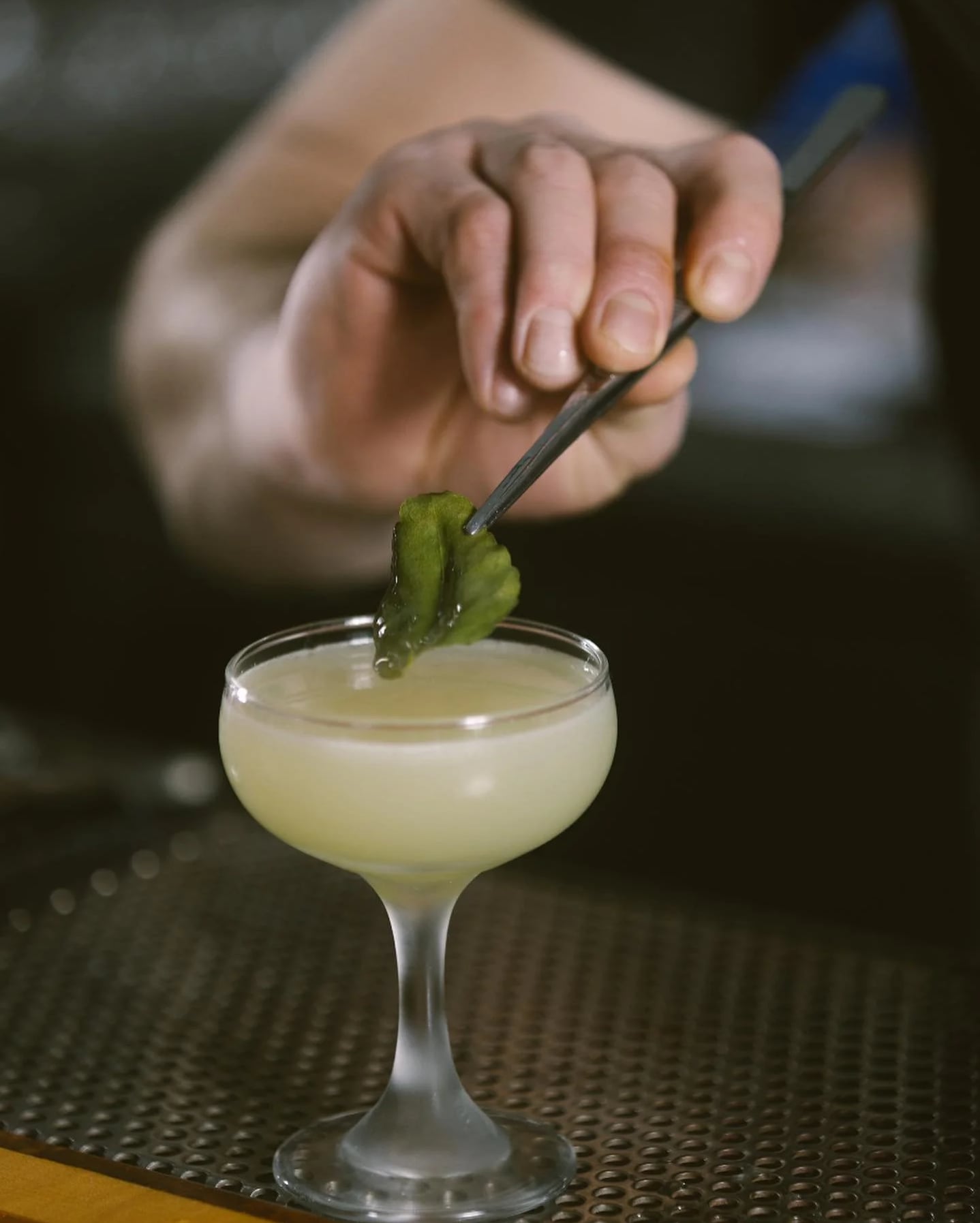 Bartender carefully garnishing a craft cocktail at Imperial.