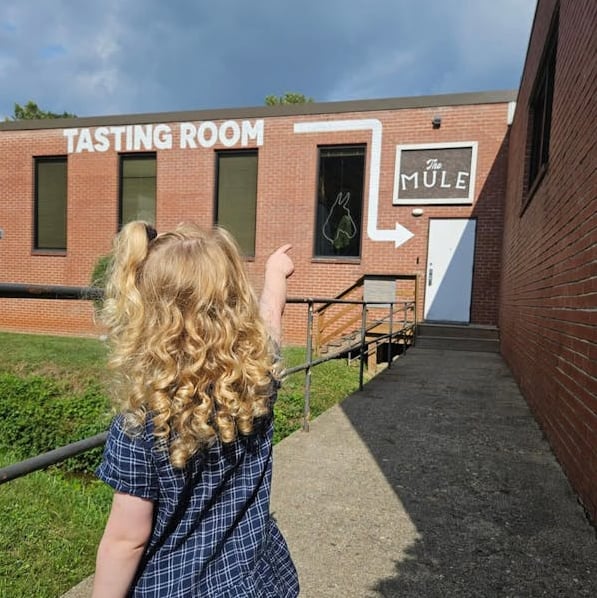 Exterior view of The Mule Tasting Room with signage and walkway.