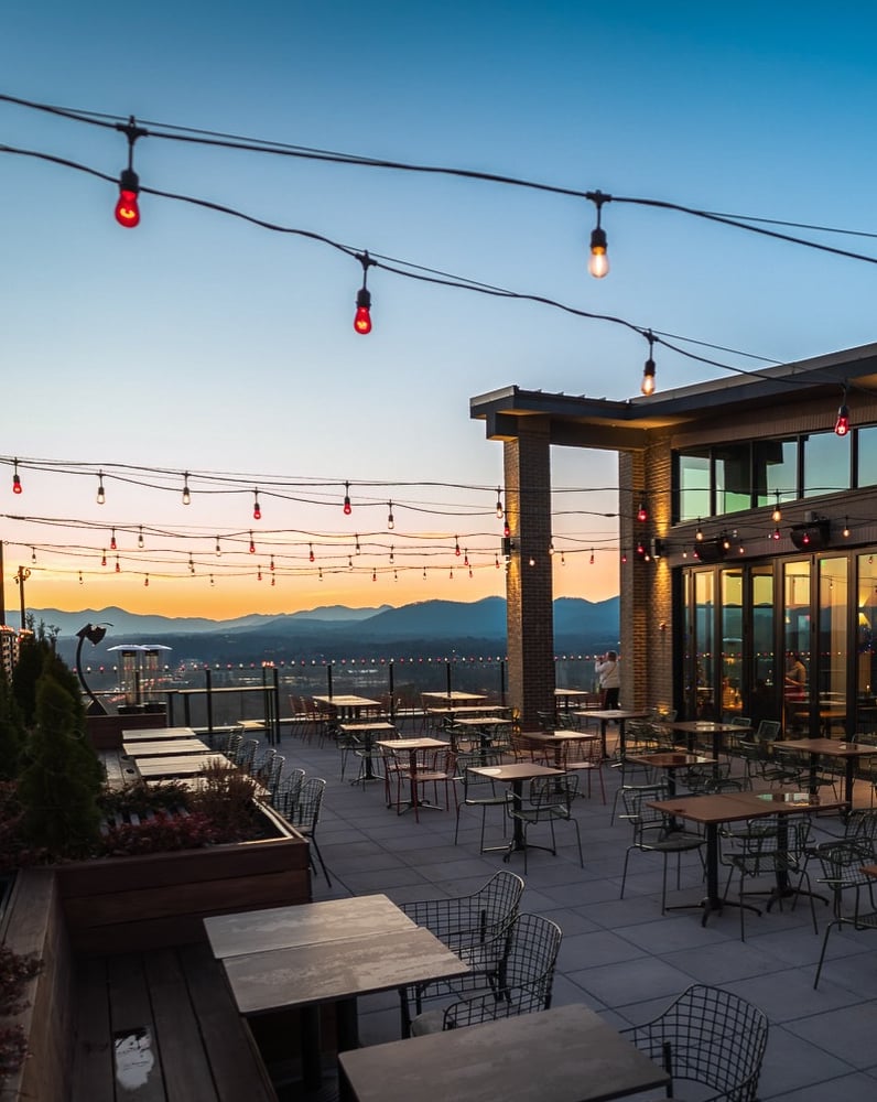 Rooftop terrace with stunning mountain views at sunset.