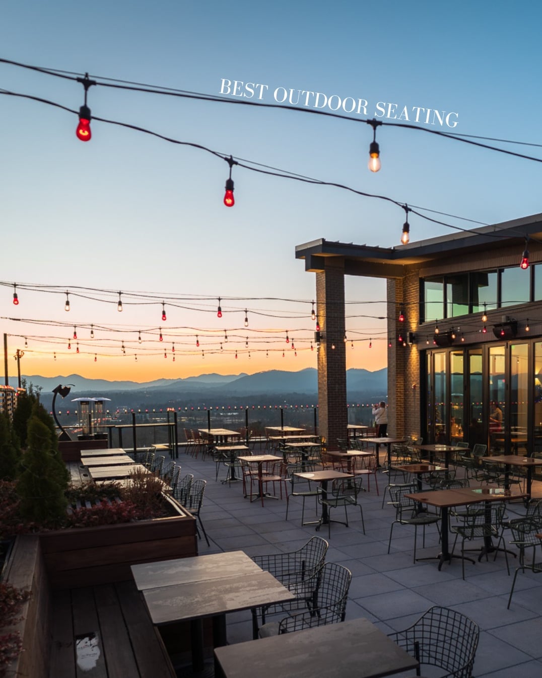 Rooftop patio overlooking the city skyline at sunset.