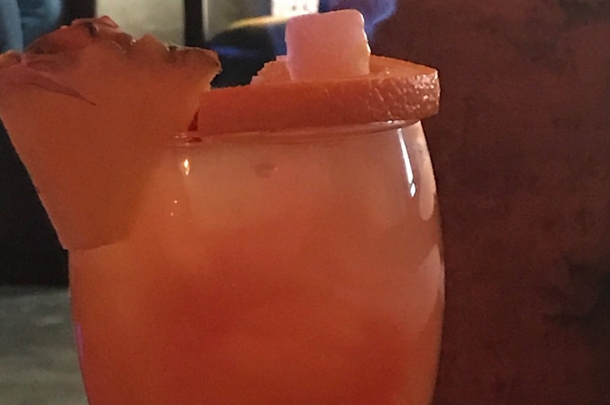 Tropical cocktail with citrus and pineapple garnish — one of the Asheville Yacht Club's signature tiki-style drinks