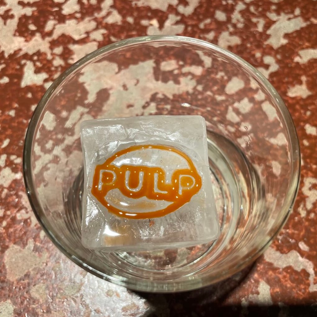 Signature Pulp branded ice cube served in a glass.