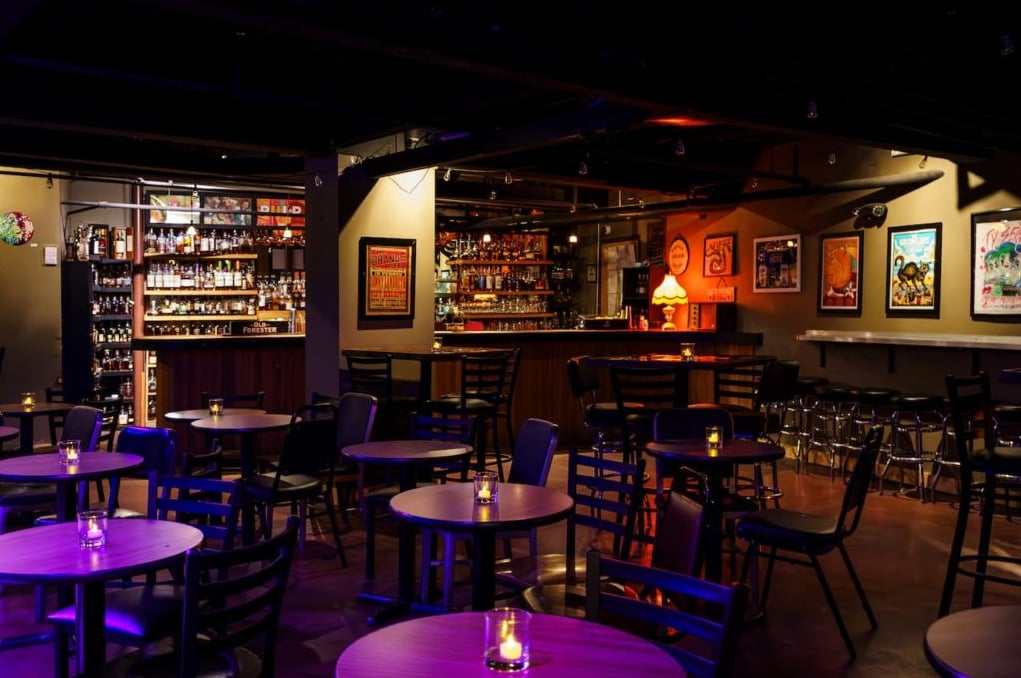 Dining room interior with dim lighting and extensive backbar selection.