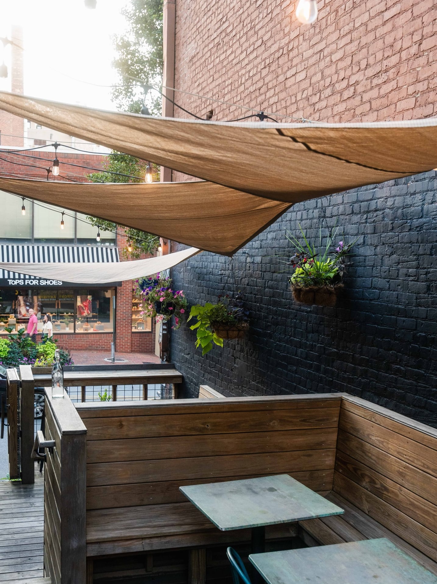 Cozy outdoor patio with sun sails and rustic wooden alcoves