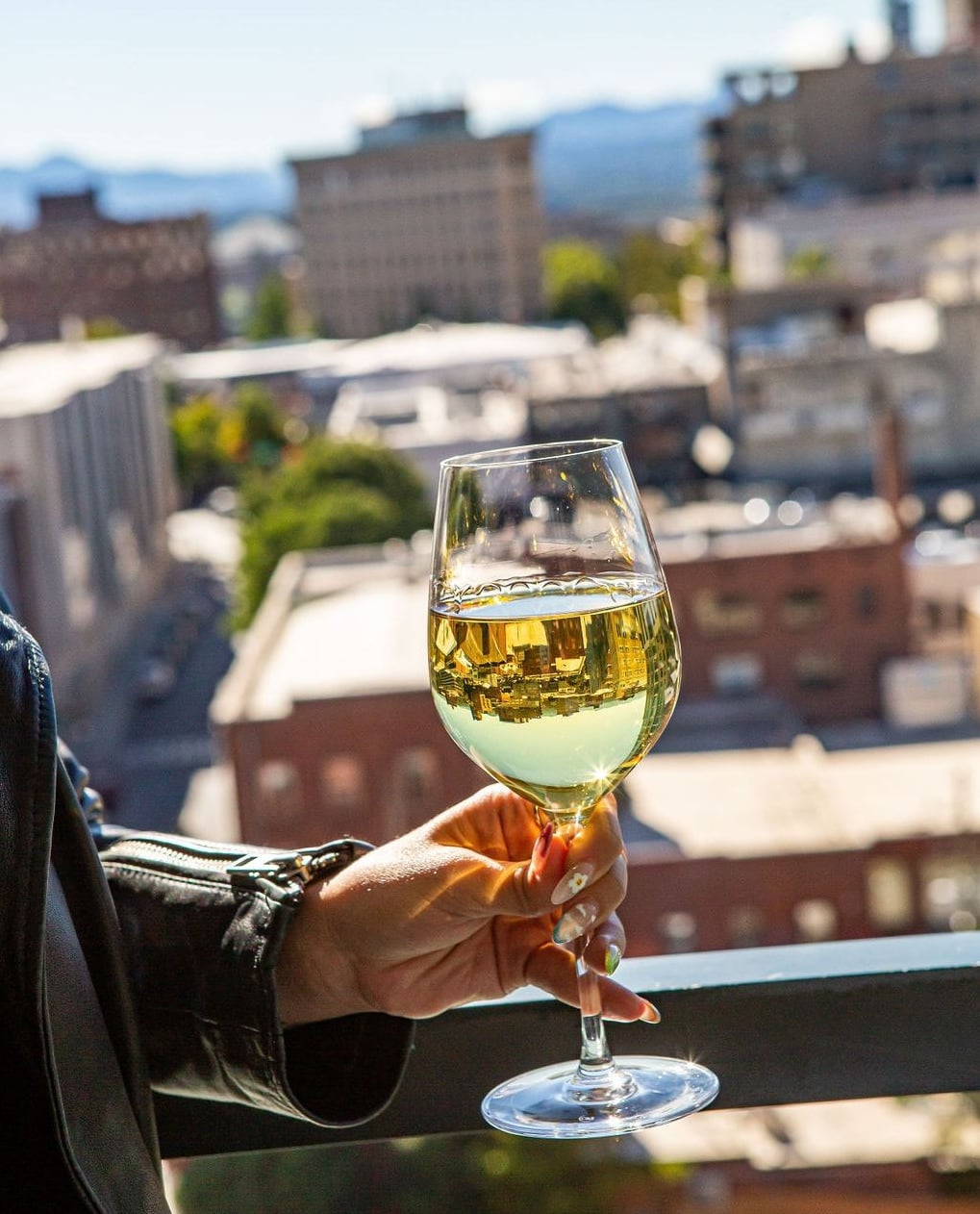 Wine service with downtown Asheville reflected in the glass